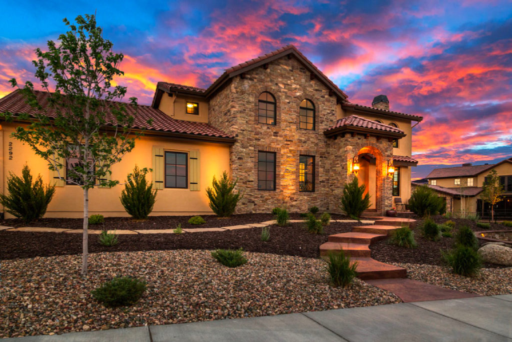 a house with a stone wall and a stone walkway