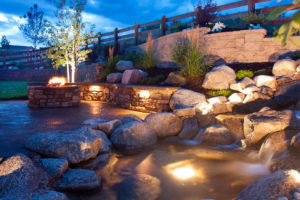 a pond with a fire pit and rocks