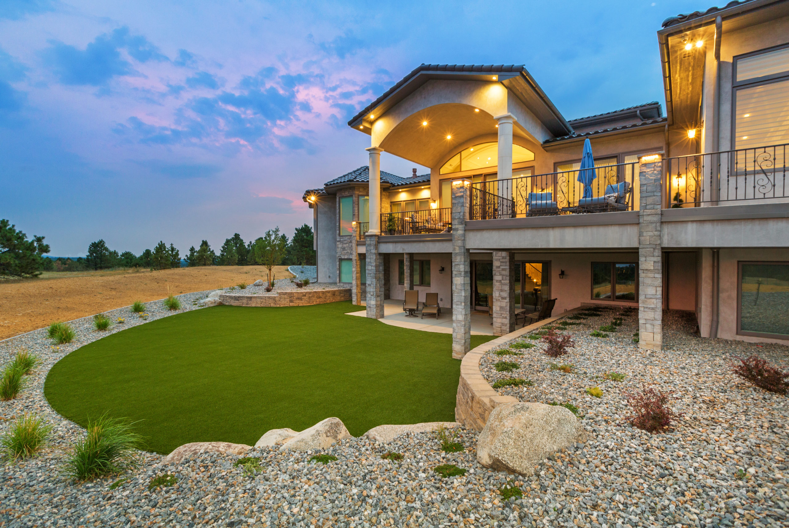 a house with a large lawn and stony walkway