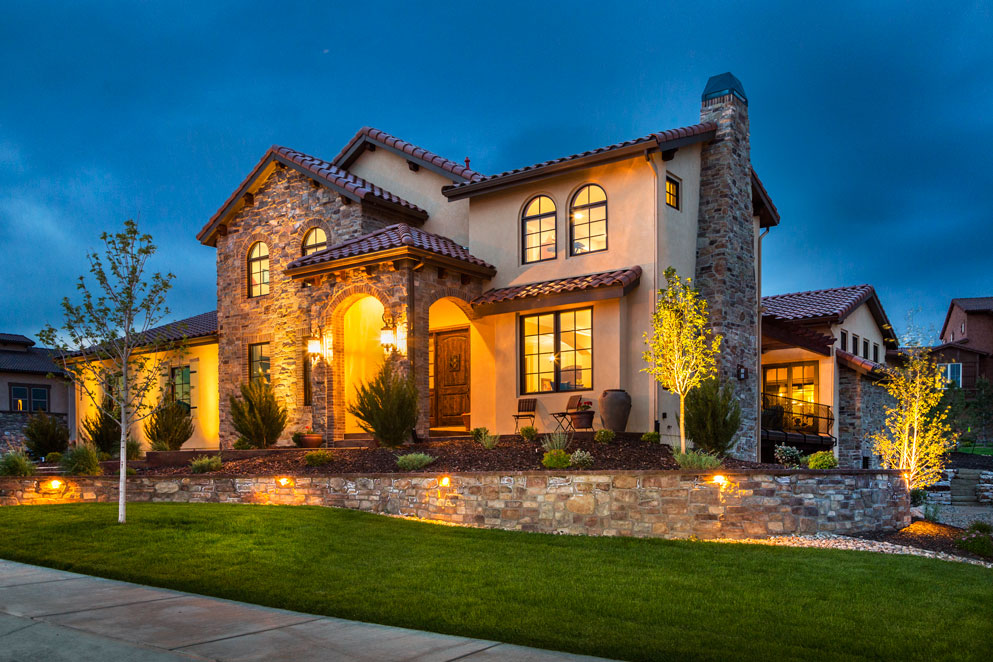 a house with a stone wall and yellow lighting