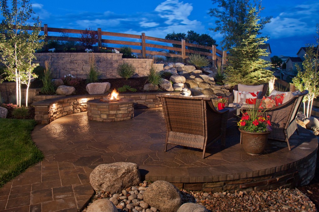 a patio with a fire pit and a fence