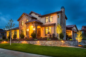 a house with a stone wall and yellow lighting